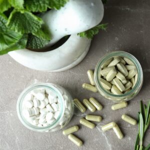 Concept of herbal medicine pills on gray textured background